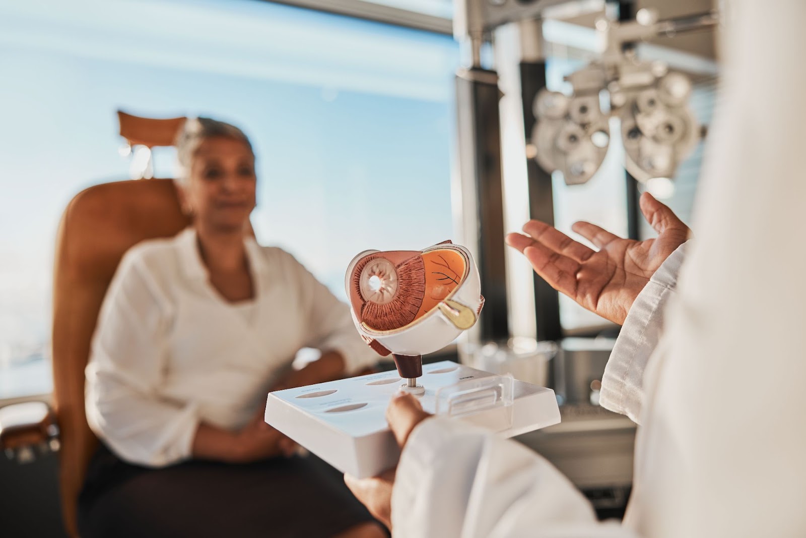 The optometrist explains to their patient how diabetes affects the eye during a diabetic eye exam.