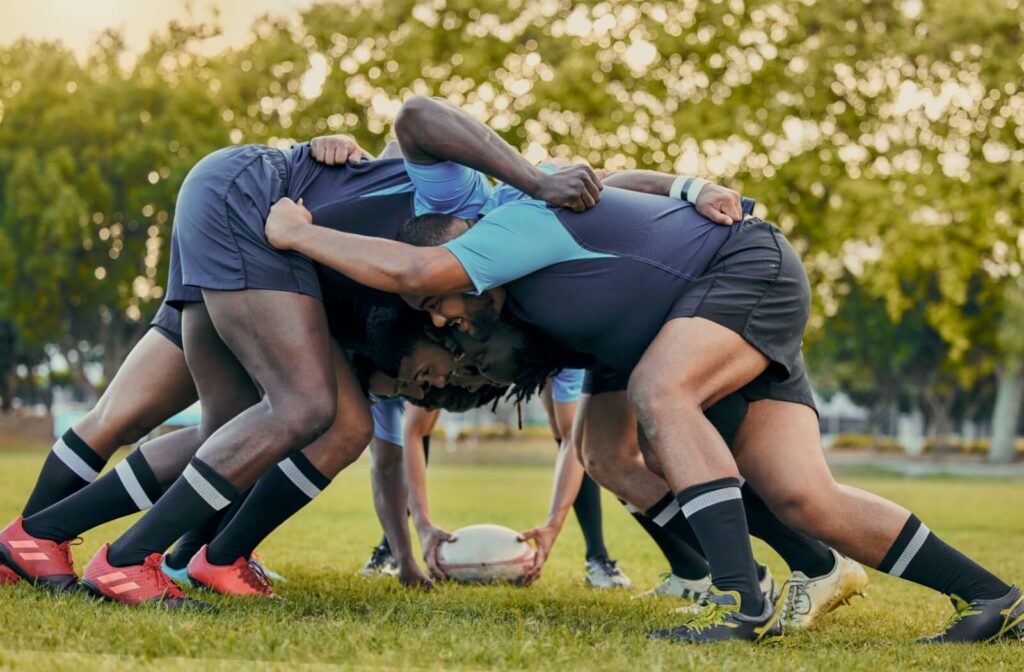 A group of men playing rugby together.