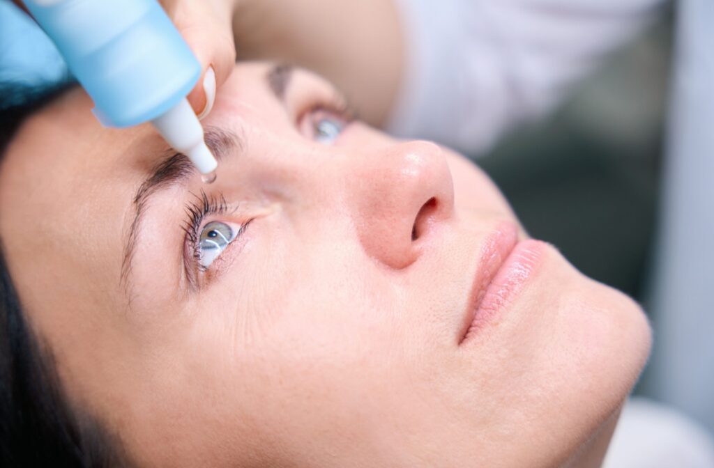 A patient receives eye drops from their optometrist to prepare for a diluted eye exam.