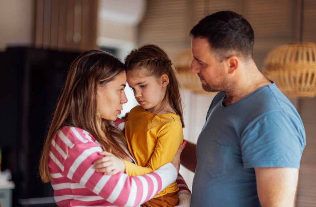 Parents reassure and comfort their child about an upcoming an eye exam.