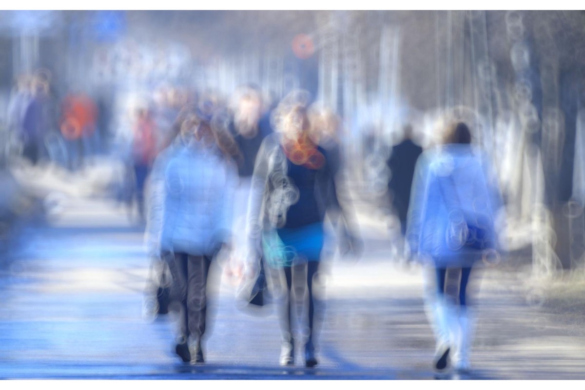 Blurry image of people walking along a pathway
